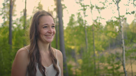 portrait of a smiling and laughing cute beautiful girl in the woods on a hike