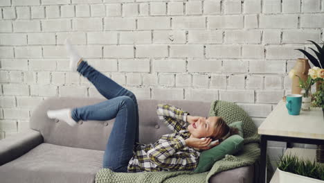 woman enjoying music on couch