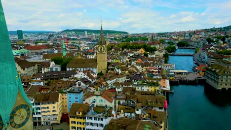4k drone video of the historic fraumünster and st. peter churches on the banks of the limmat river in downtown zurich, switzerland