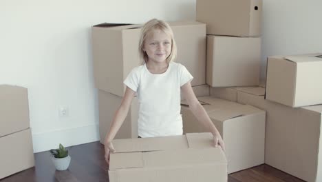 dulce niña de cabello claro posando en un nuevo apartamento