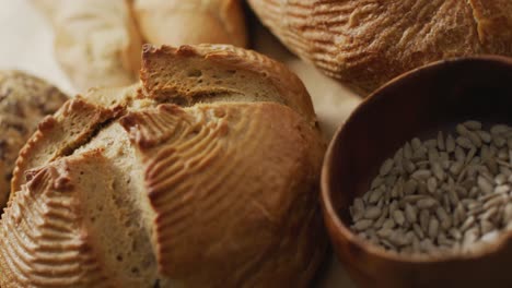 Video-Von-Brötchen-Und-Brot-Auf-Backpapier-Auf-Einer-Holzarbeitsplatte