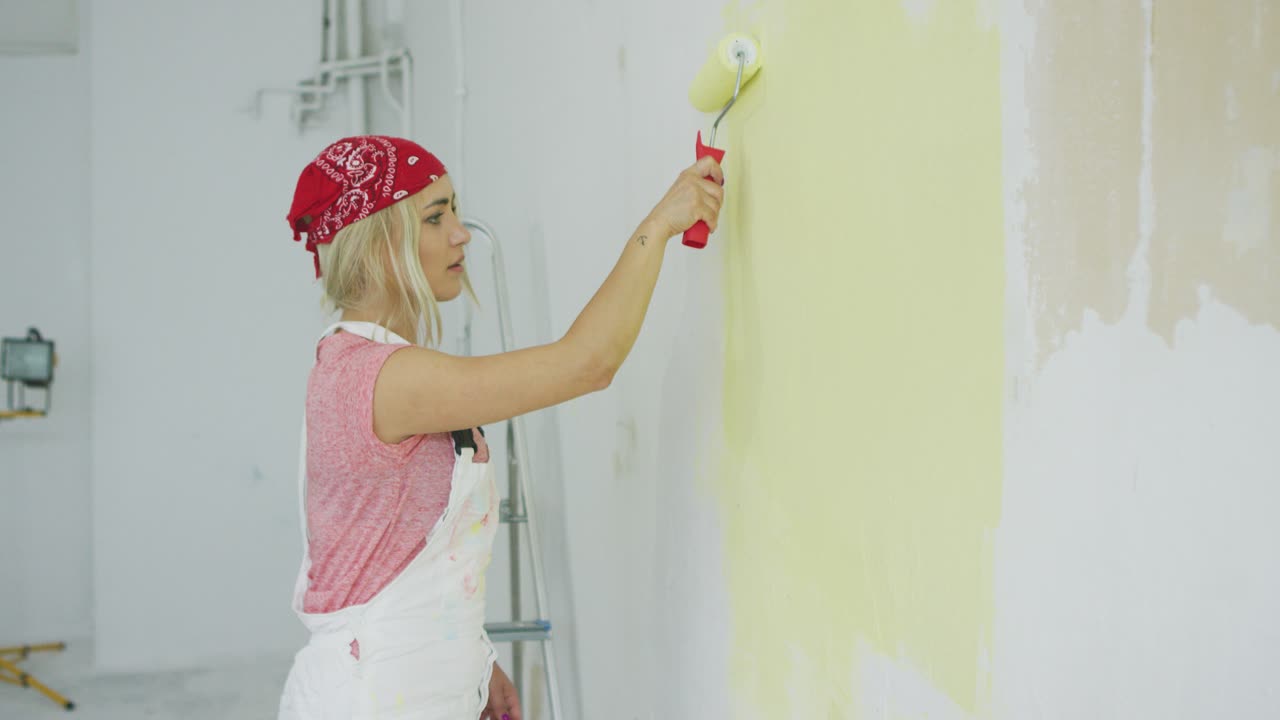 mujer pintando pared con rodillo