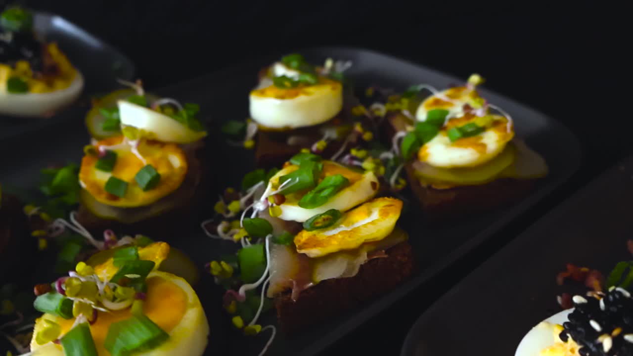 Cinematische close-up van traditionele Estse gevulde eieren met kaviaar en sprot roggebroodjes geserveerd op donkere borden voor Onafhankelijkheidsdag viering