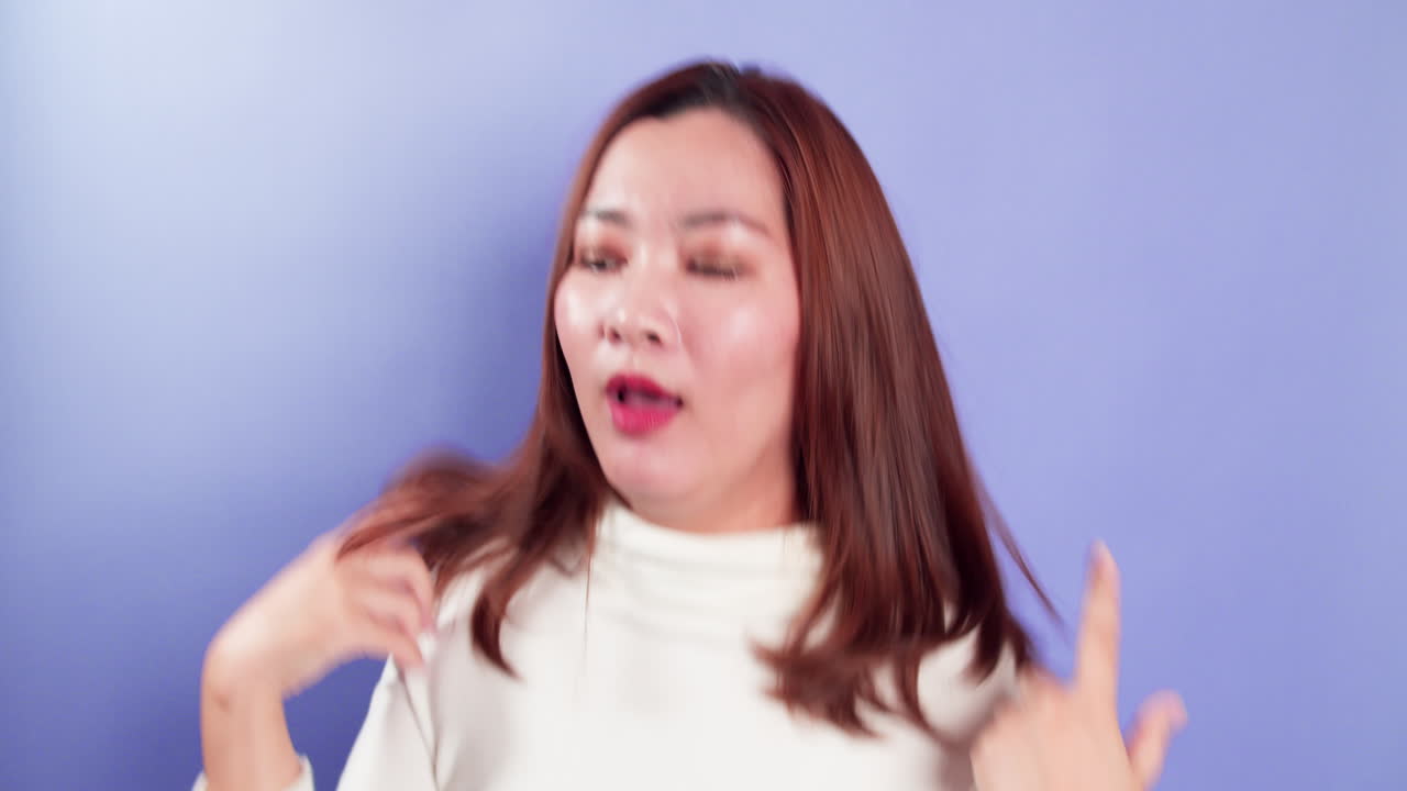 보라색 배경-2에 고립된 휴식 실내 스튜디오 촬영과 함께 젊은 아시아 쾌활한 여성 장난 음악 댄스