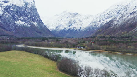 Asphalt-Road-By-The-Lake-Water-At-The-Feet-Of-Trollveggen-Mountain-In-More-og-Romsdal-County,-Norway