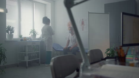 hombre recibiendo la vacuna de covid en la oficina de la clínica. mujer médico haciendo inyecciones.