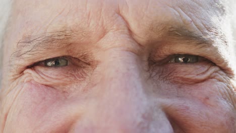 retrato de cerca de los ojos de un hombre caucásico mayor feliz e inalterado, en cámara lenta
