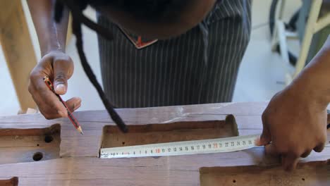 Carpenter-measuring-wood-with-tape-4k