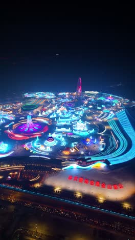 vertical aerial night view of harbin ice festival illuminated in vibrant lights, creating a magical winter spectacle. china