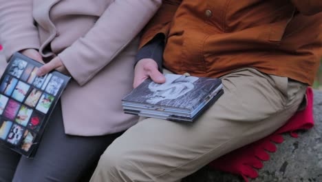 couple holding photo albums outdoors