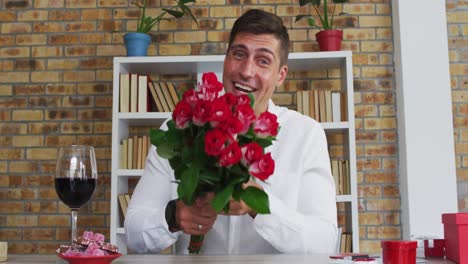 Hombre-Caucásico-Haciendo-Videollamada-Presentando-Un-Ramo-De-Flores-Lanzando-Un-Beso-Y-Sonriendo