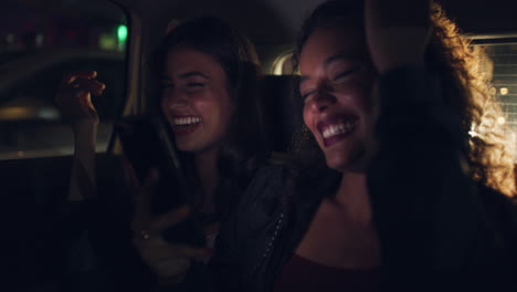 two friends having fun in a car at night