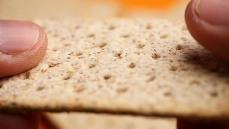 close-up of a person holding a wheat cracker