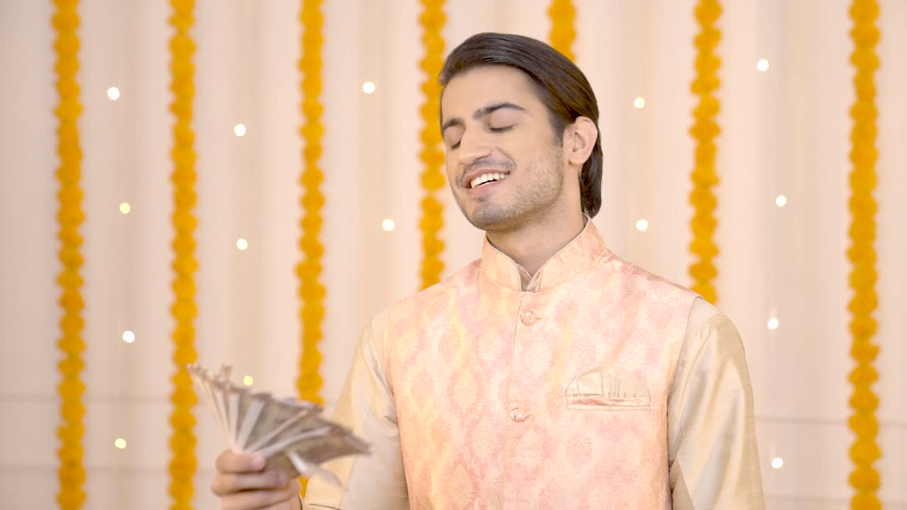 hombre indio usando dinero como ventilador