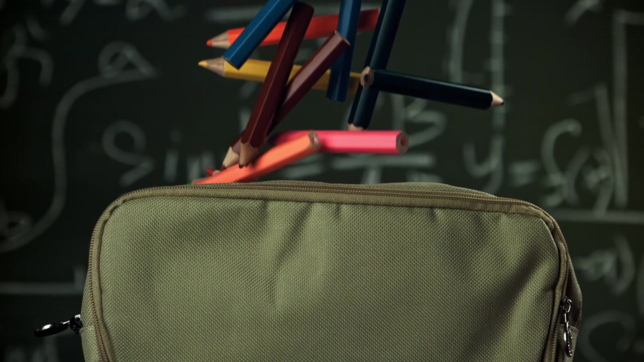 Barevné tužky padající do penálu s pozadím matematické tabule