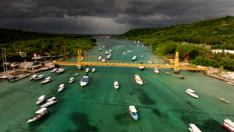 Barcos-Flotando-En-El-Mar-De-Bali-Con-Un-Puente-Amarillo-Entre-Nusa-Lembongan-Y-La-Isla-Ceningan-En-Indonesia.