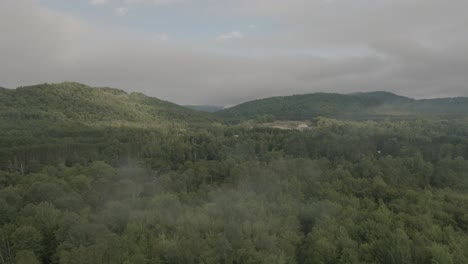 Drone-Volando-A-Través-De-Un-Hermoso-Paisaje-Neblinoso-En-La-Cima-De-La-Montaña,-Sobre-Un-Río-1