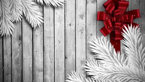 Video-composition-with-snow-over-Christmas-gift--ribbon-on-wood