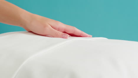 Woman inspecting the quality of a white pillow