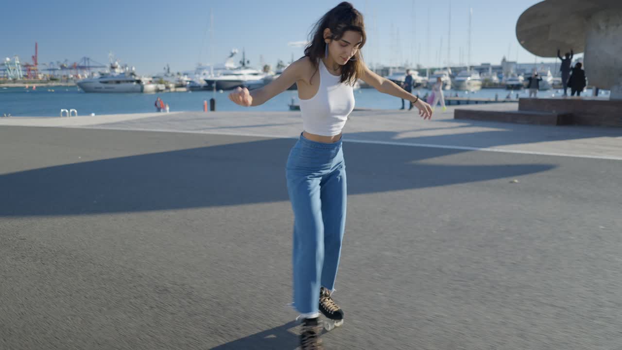 Young woman roller skating at a waterfront city