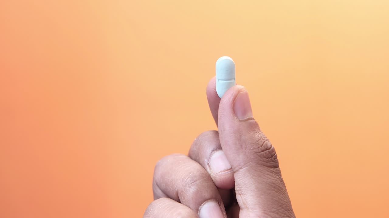 밝은 회색 약을 들고 있는 손