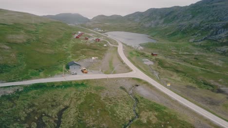 Panorámica-Mientras-Se-Avanza-Con-Un-Dron-Disparado-Junto-A-Lagos,-Colinas-Y-Un-Campamento