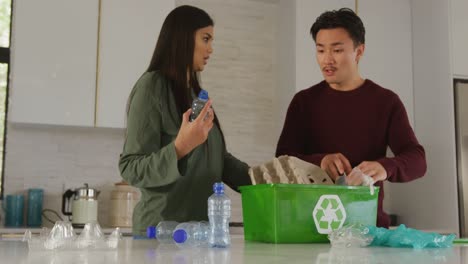 video of diverse couple collecting bottles for recycling