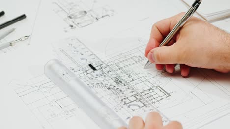 hands working on architectural blueprints