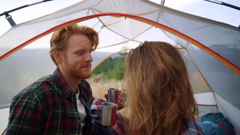 woman taking care about man hair in camping tent