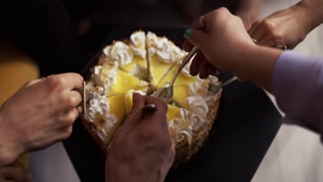 people grabbing cake slices using forks