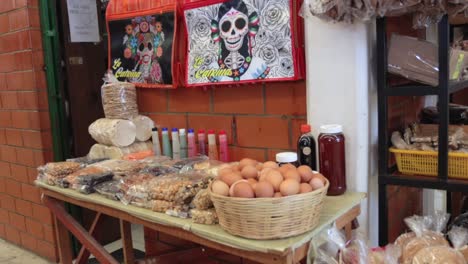 a local stand in a market selling organic foods like eggs, nuts, spices juices and oils