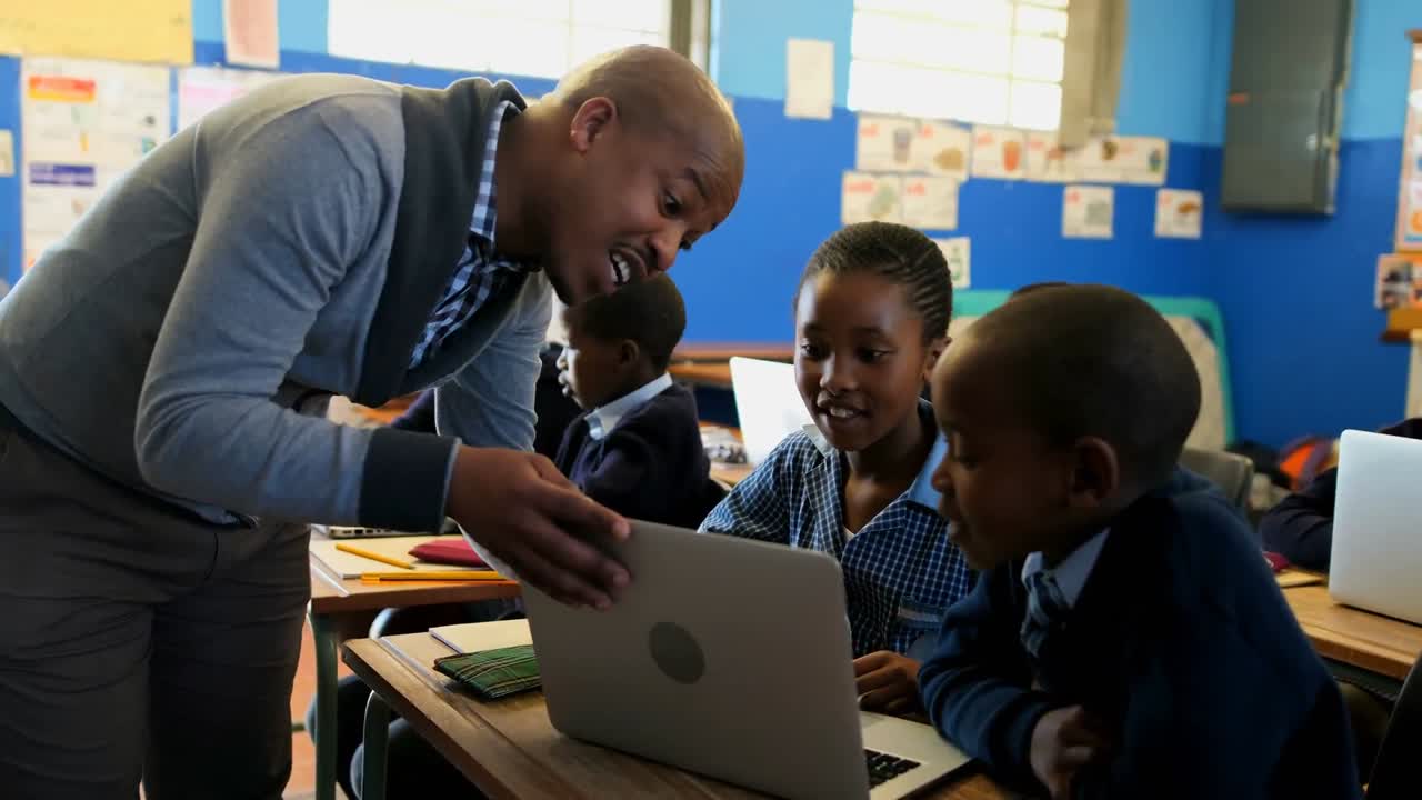 Male teacher teaching students on laptop in the classroom 4k