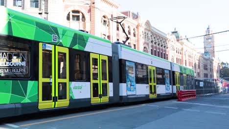 tram moving past historic melbourne train station