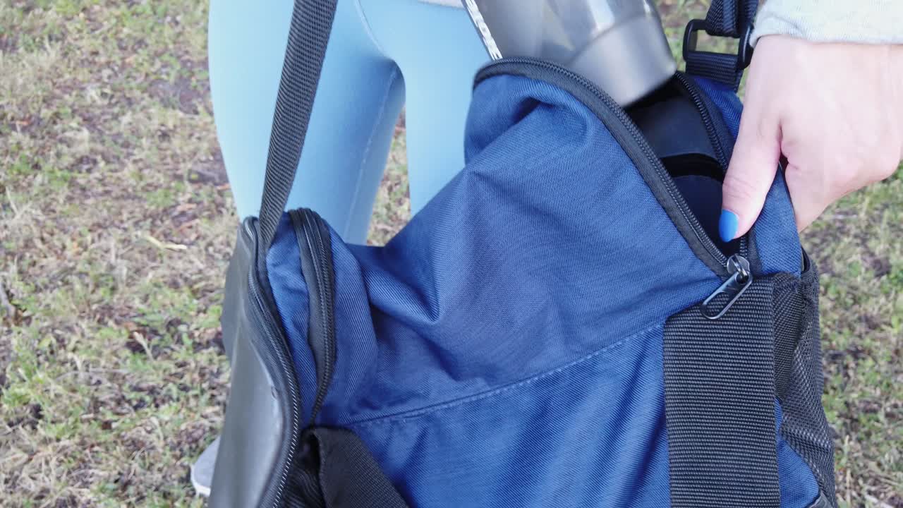 체육관 가방에서 느린 동작으로 체육관 병을 꺼내는 소녀