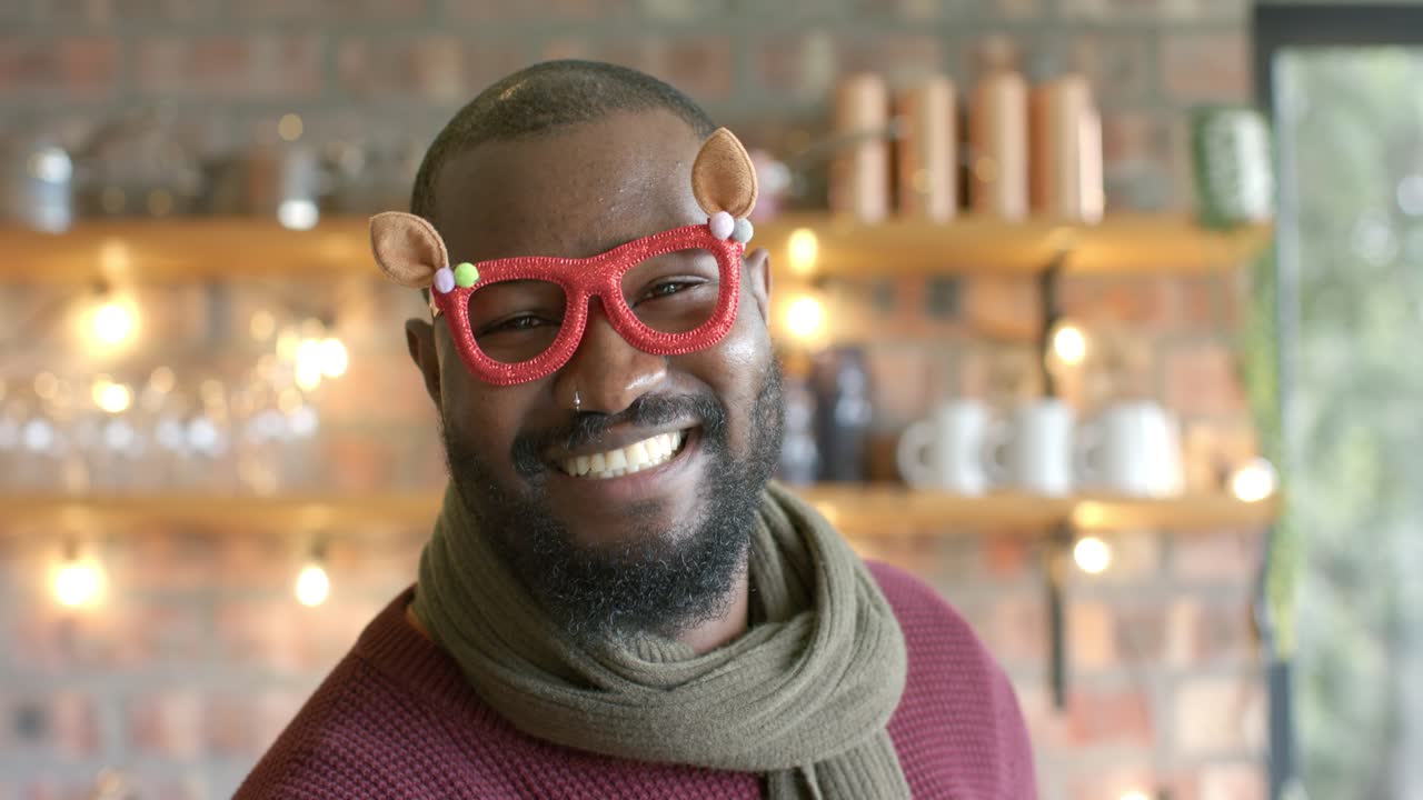 African American man wearing red novelty glasses turning toward camera after spotting lens at cafe