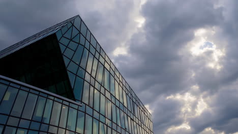 modern glass building against a cloudy sky