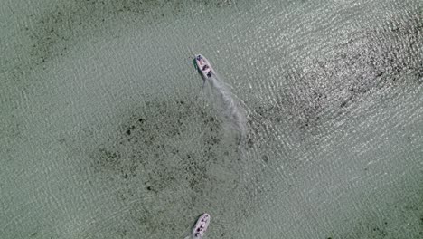 plano cenital de un barco en un mar colorido