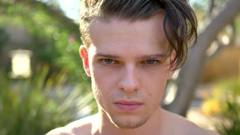 a close up of a young attractive white man with green eyes looking very mad, upset and angry