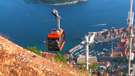 Editorial:-Teleférico-Ascendiendo-Sobre-La-Ciudad-Medieval-Amurallada-De-Dubrovnik,-Croacia-En-2015-Con-El-Mar-Adriático-Y-La-Isla-De-Lokram-Al-Fondo