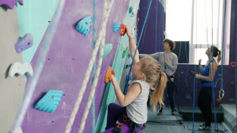 young girl rock climbing indoor