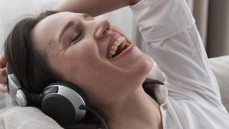 relaxed woman singing and listening song in headphones