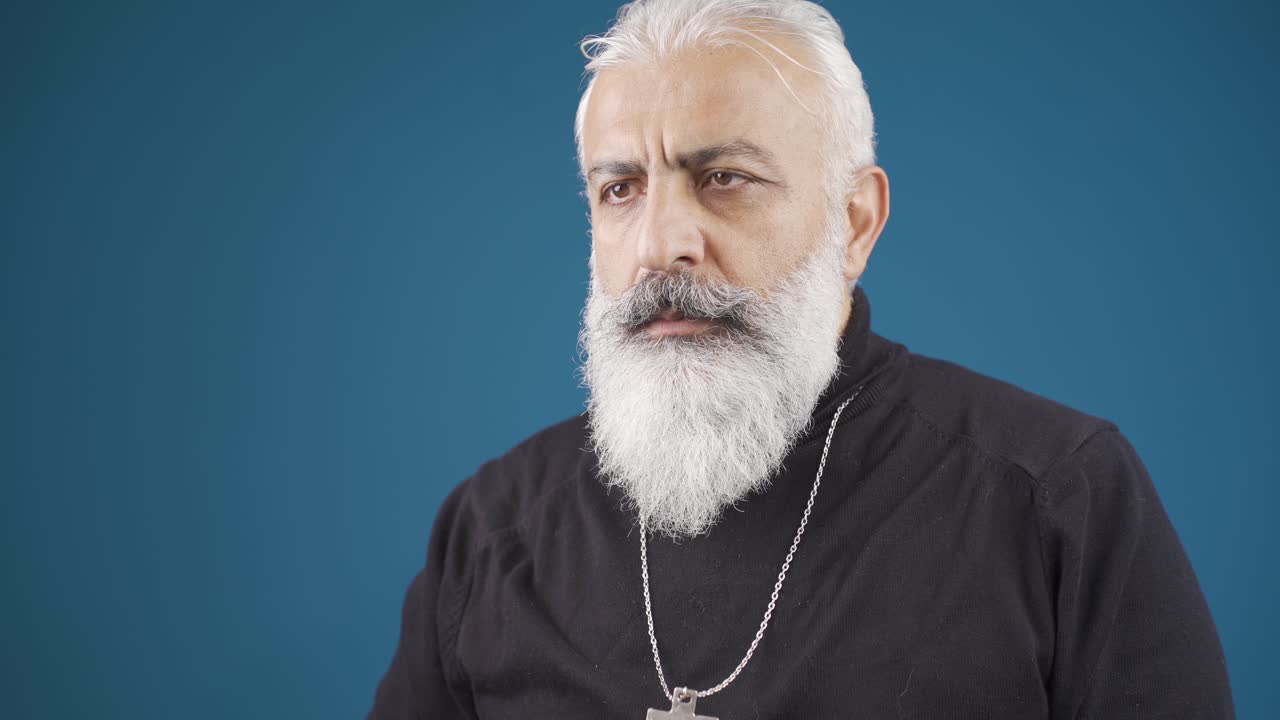 un joven cristiano maduro besando y respetando un collar de cruz.