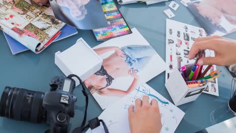 패션 스튜디오에서 일하는 패션 디자이너들의 다양한 그룹이 테이블 위에 카메라와 이미지를 가지고 있습니다.