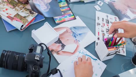 diverse group of fashion designers working in fashion studio with camera and images on table