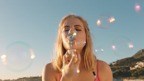 beautiful woman blowing bubbles on beach at sunset enjoying summer having fun on vacation by the sea