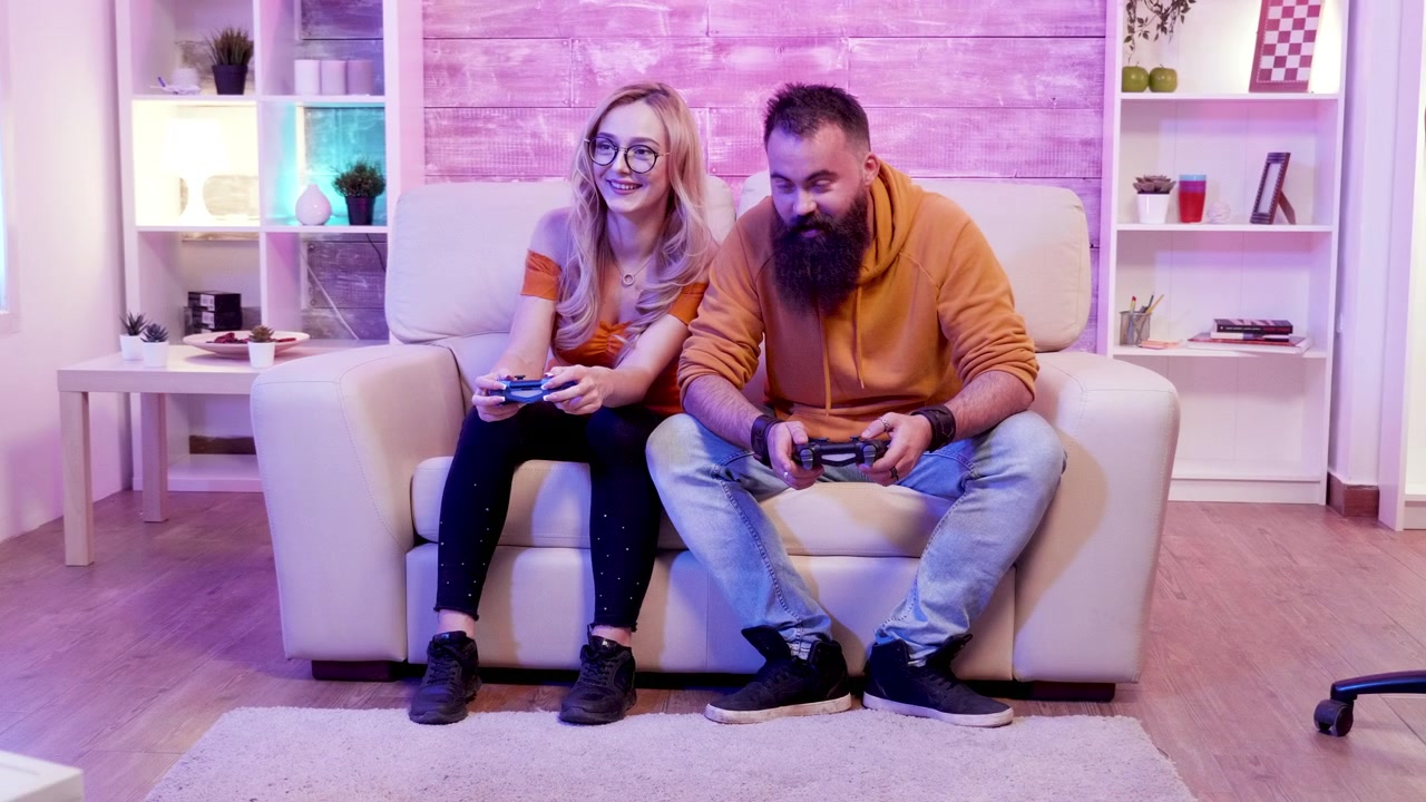 Young couple relaxes at home with wireless console gameplay