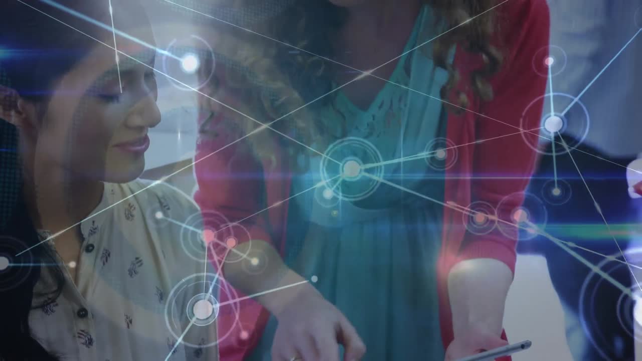 animación de una red de conexiones sobre dos mujeres diversas discutiendo sobre una tableta digital