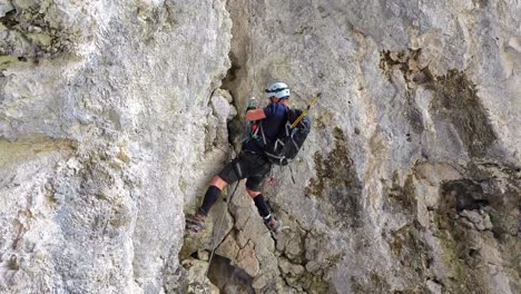a mountaineer ascends a rocky peak in alta badia, dolomites, italy - slow motion