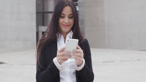 Attractive-businesswoman-checking-her-mobile-teléfono