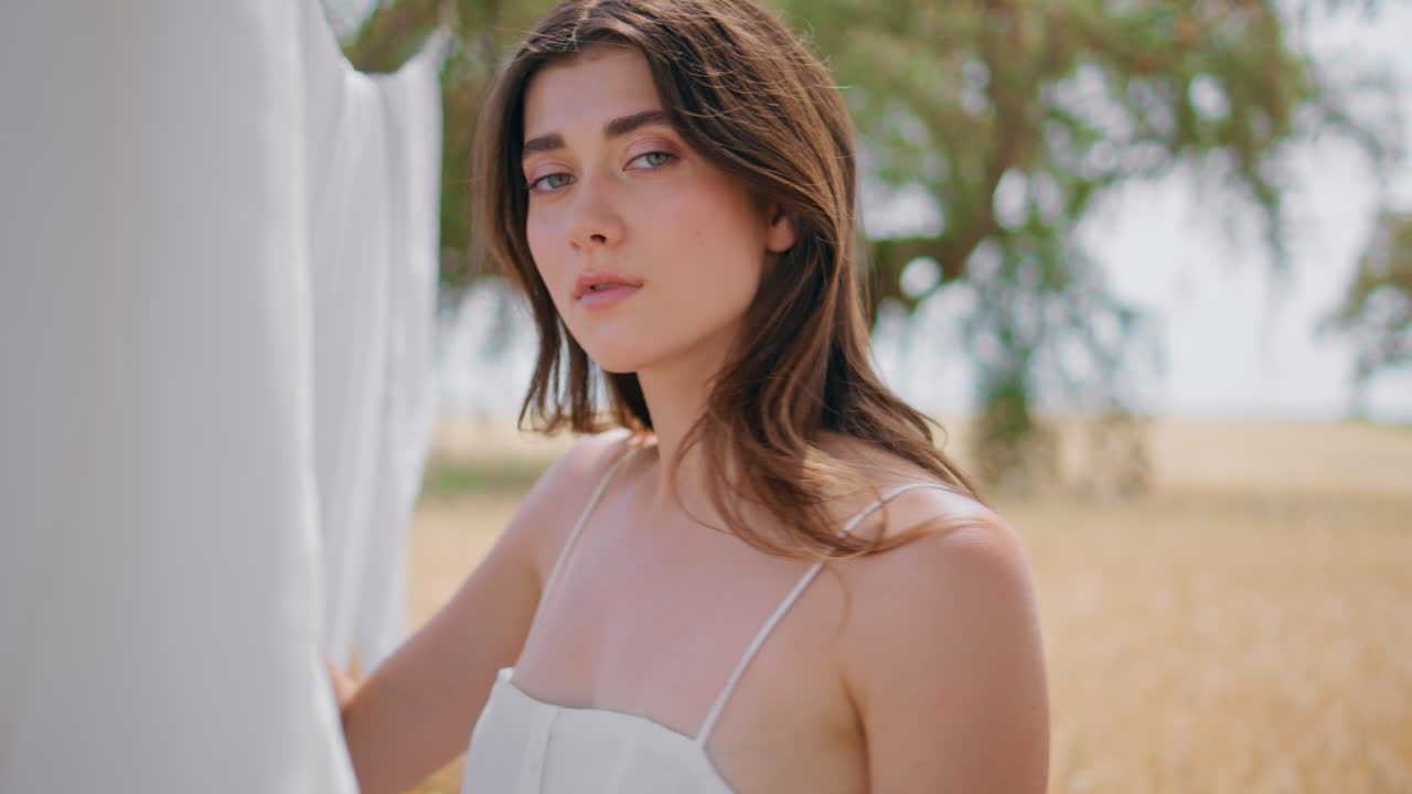 여름의 신선한 공기를 즐기는 시골 소녀 정원 근접. 카메라를 찾는 젊은 여성